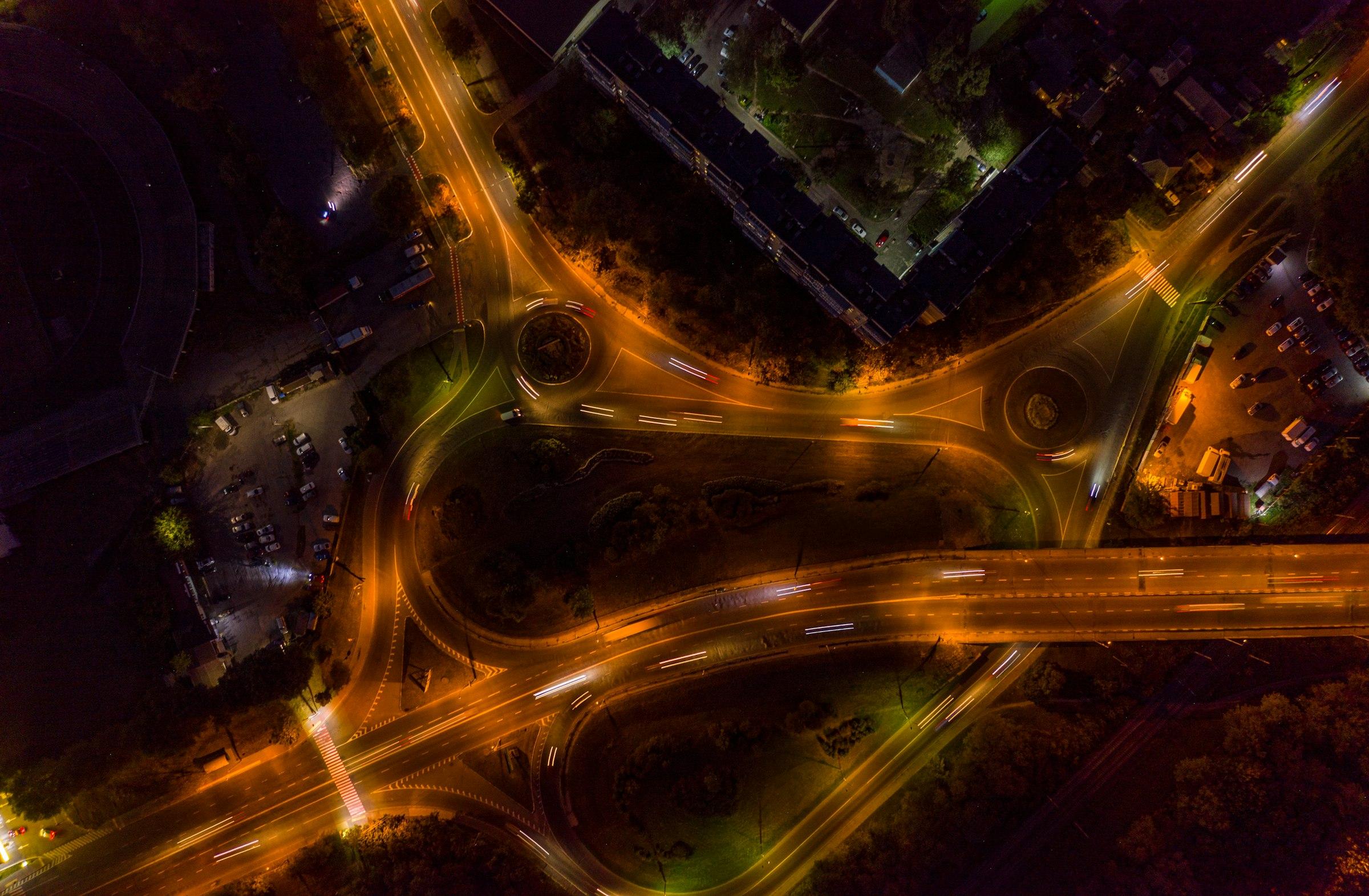 Aerial view of a highway interchange at night, lit in amber